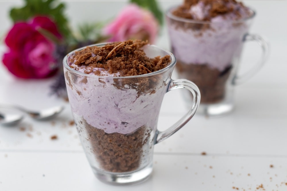 Schichtdessert im Glas mit Blaubeeren und Kuchen